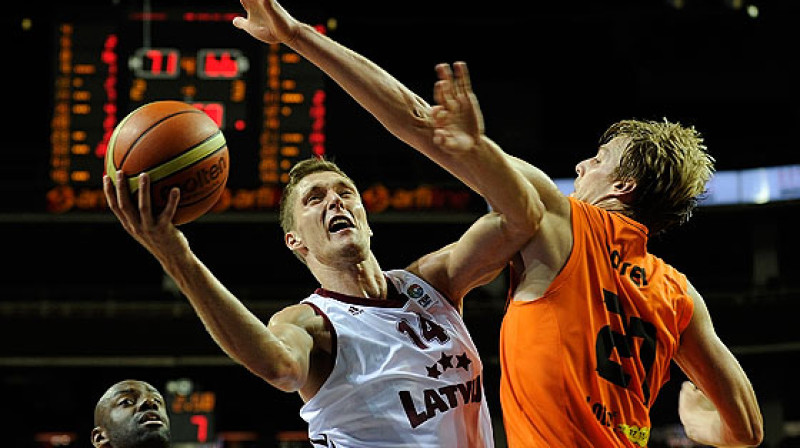 Kaspars Bērziņš pret Nīderlandes izlases centru Henku Norelu.
Foto: fibaeurope.com (Romans Kokšarovs)