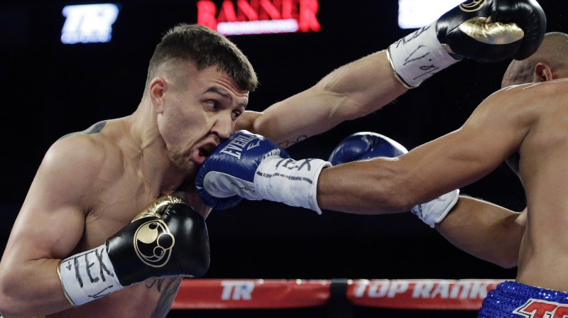 Vasīlijs Lomačenko saņem sitienu no Orlando Salido. Foto: AP/Scanpix