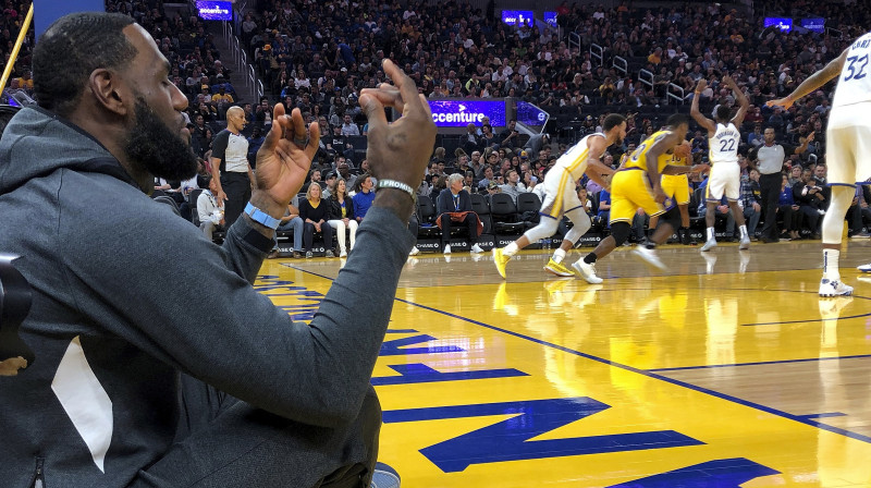 Lebrons Džeimss no laukuma malas noraugās Losandželosas "Lakers" spēli pret Goldensteitas "Warriors". Foto: AP/Scanpix