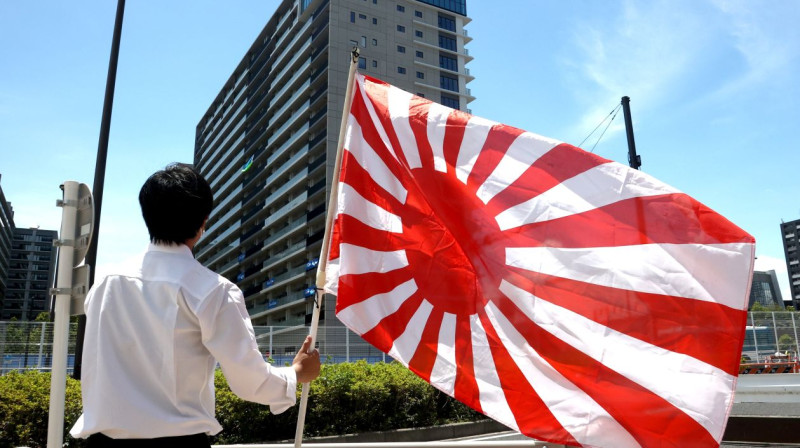 Protestētājs ar Japānas imperiālo karogu. Foto: EPA/Scanpix