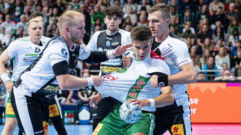 Renārs Uščins pretinieku tvērienā. Foto: Jan Günther/TSV Hannover-Burgdorf